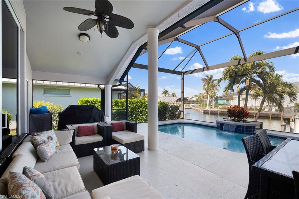 View of swimming pool with pool water feature, a patio area, a water view, outdoor lounge area, and a lanai