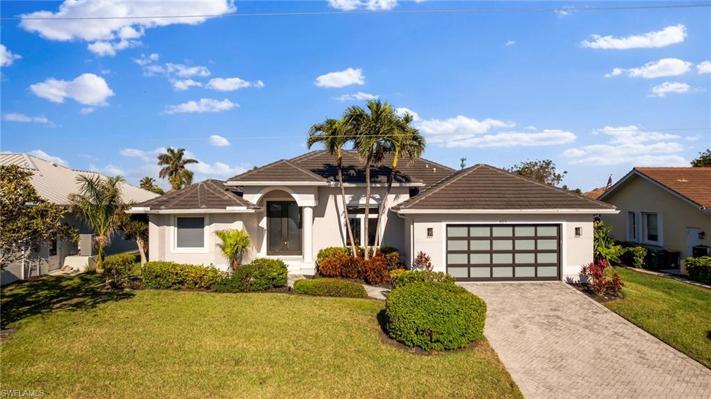 View of front of property featuring a garage and a front yard