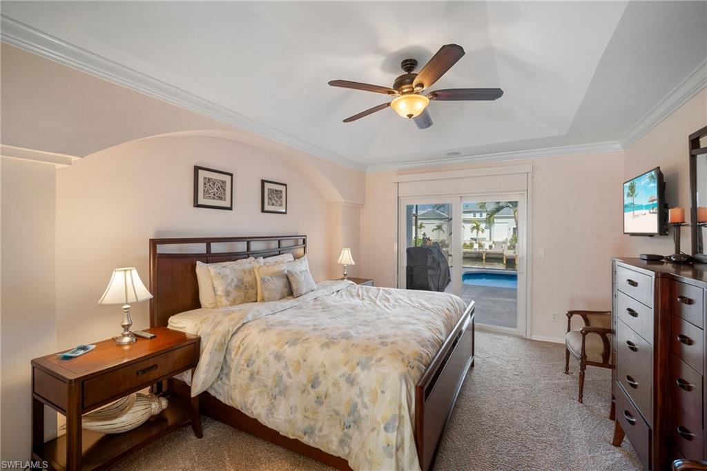 Carpeted bedroom featuring crown molding, access to exterior, and ceiling fan