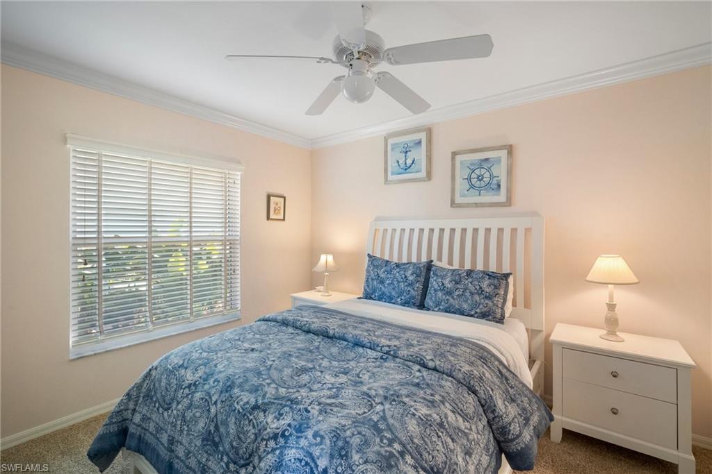 Bedroom with ornamental molding, carpet, and ceiling fan