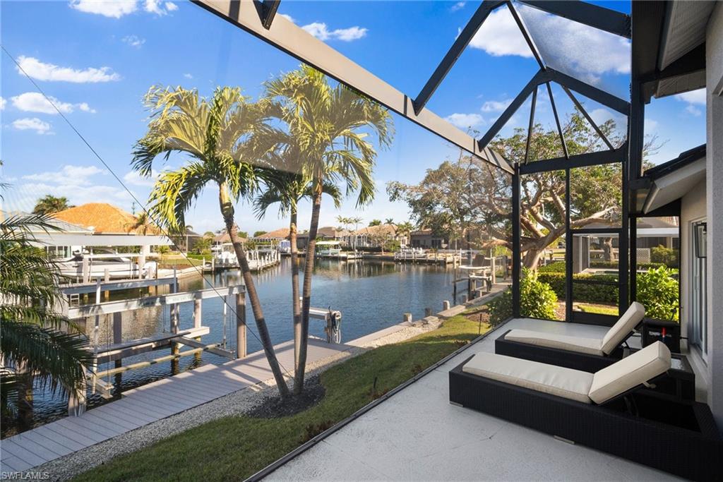 View of patio with a water view and a dock