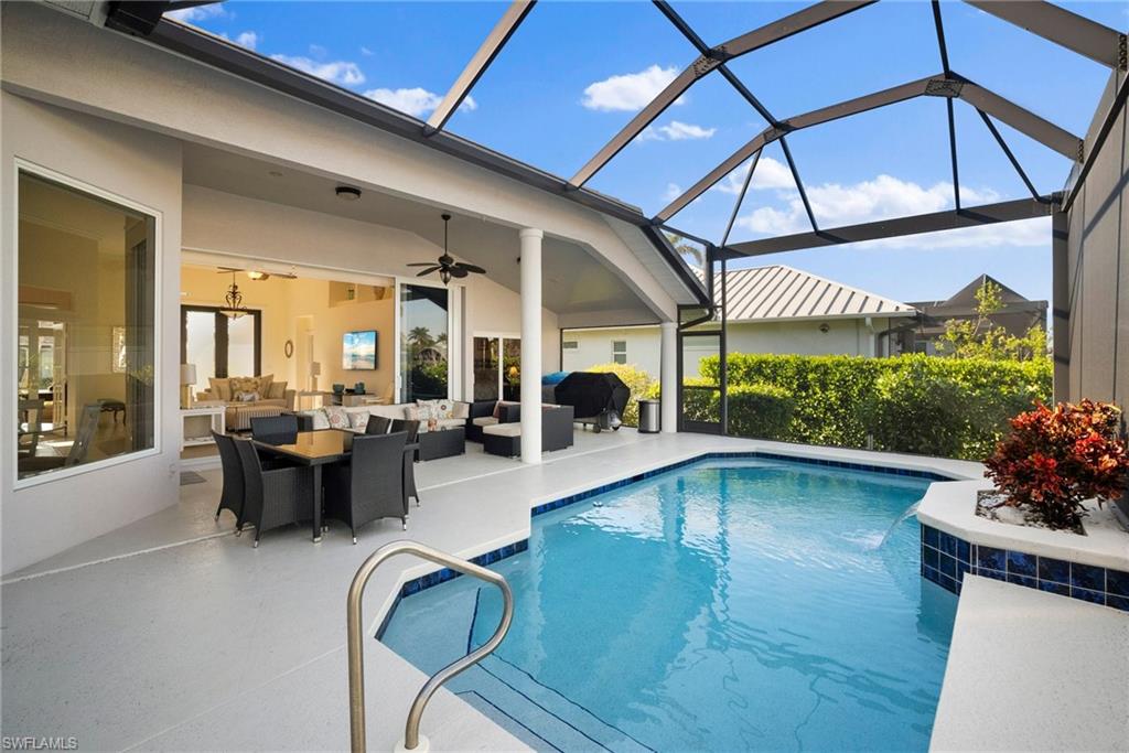 View of swimming pool with an outdoor hangout area, a patio, ceiling fan, and glass enclosure