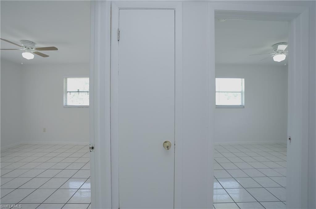 Interior space featuring white tiled flooring and white walls