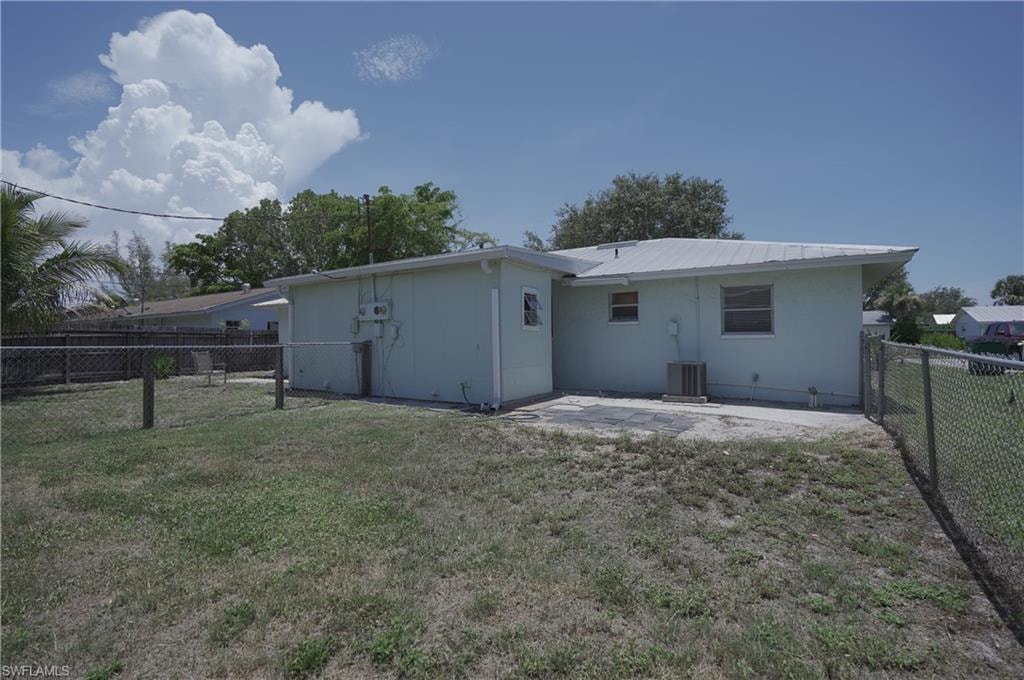 The property features a fenced yard, a rear patio, and a light-colored exterior