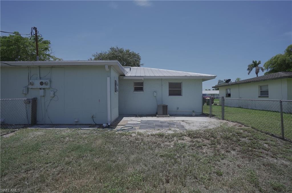 The property features a patio area with pavers, a chain-link fence, and a metal roof