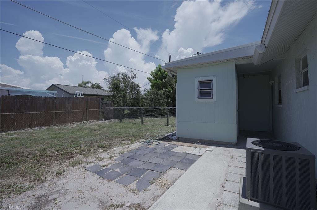 The property features a fenced yard, a patio area with pavers, and an external air conditioning unit
