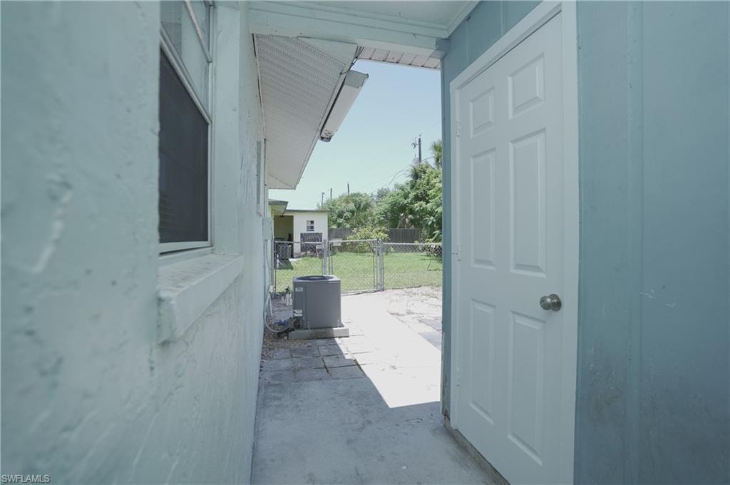 The property features an exterior with light-colored siding, a window with blinds, and a white door