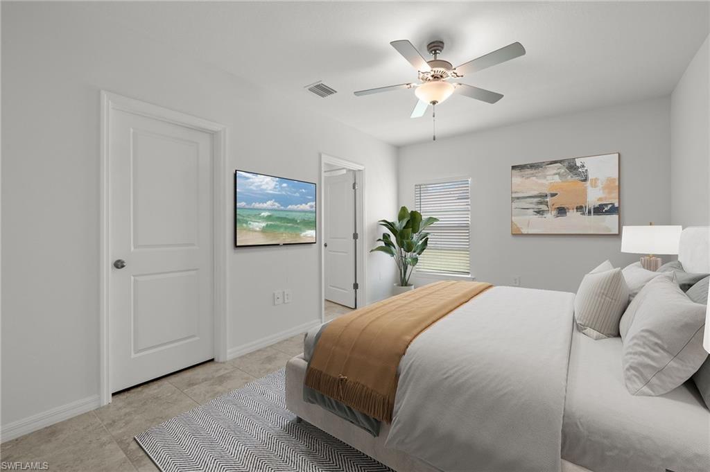 Tiled bedroom featuring multiple windows and ceiling fan