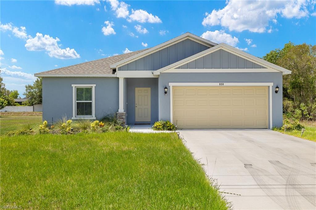 View of front facade with a garage and a front lawn