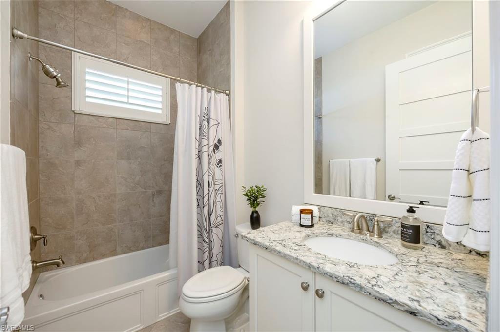 Full bathroom with a linen closet and window