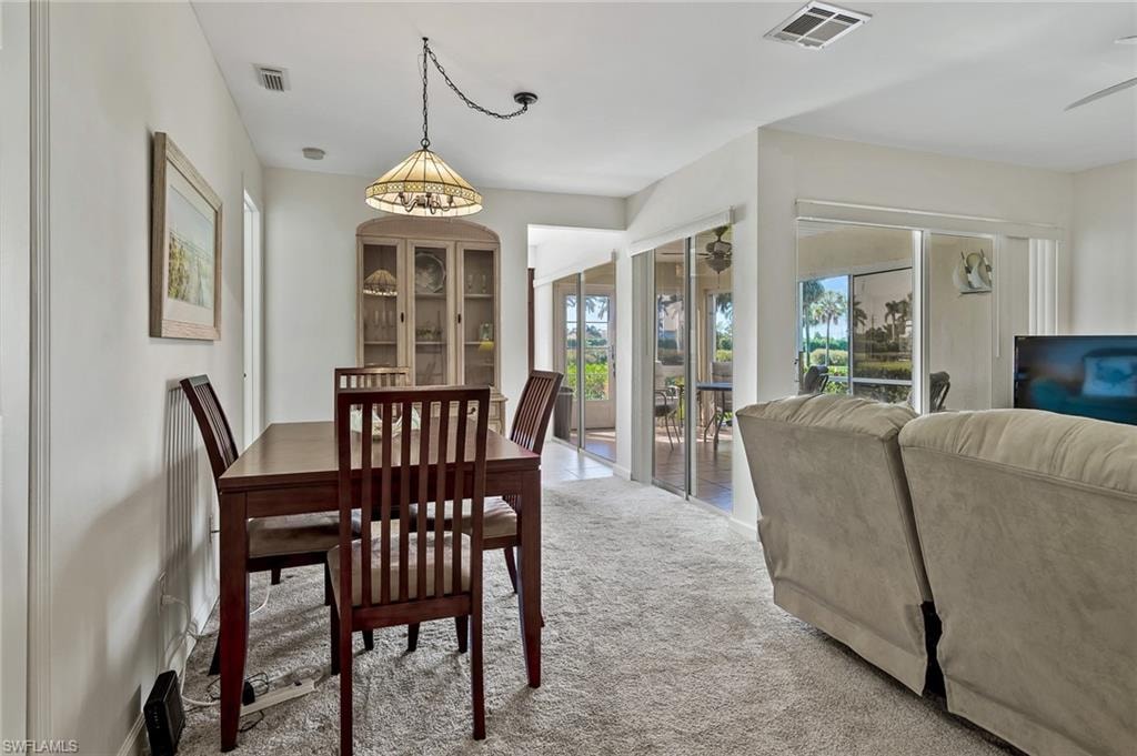 Carpeted dining space with visible vents