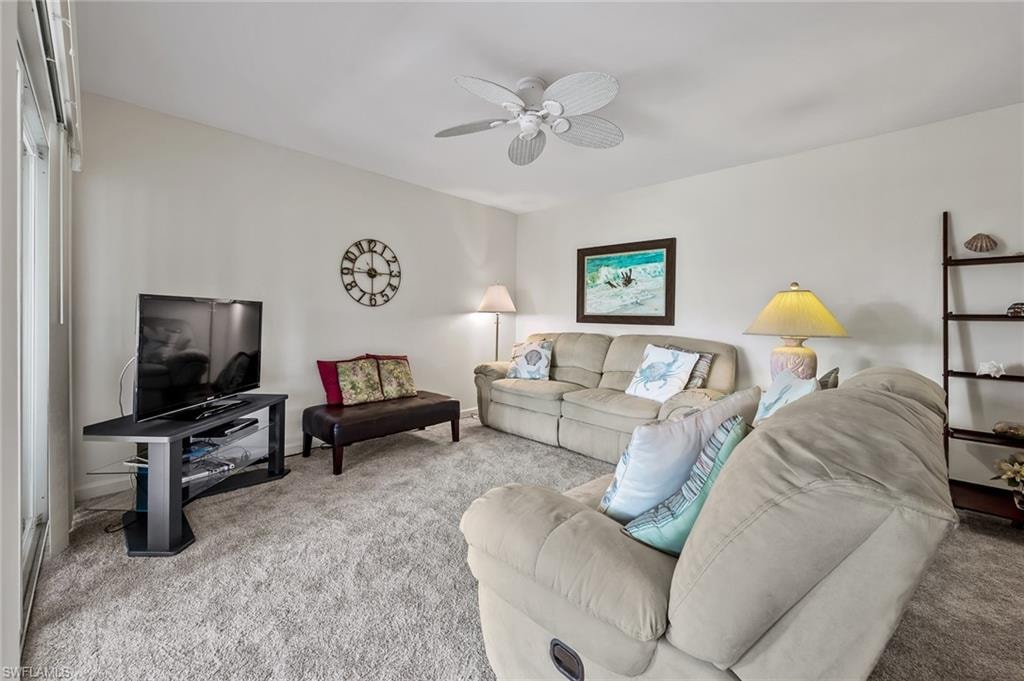 Living room with carpet and a ceiling fan