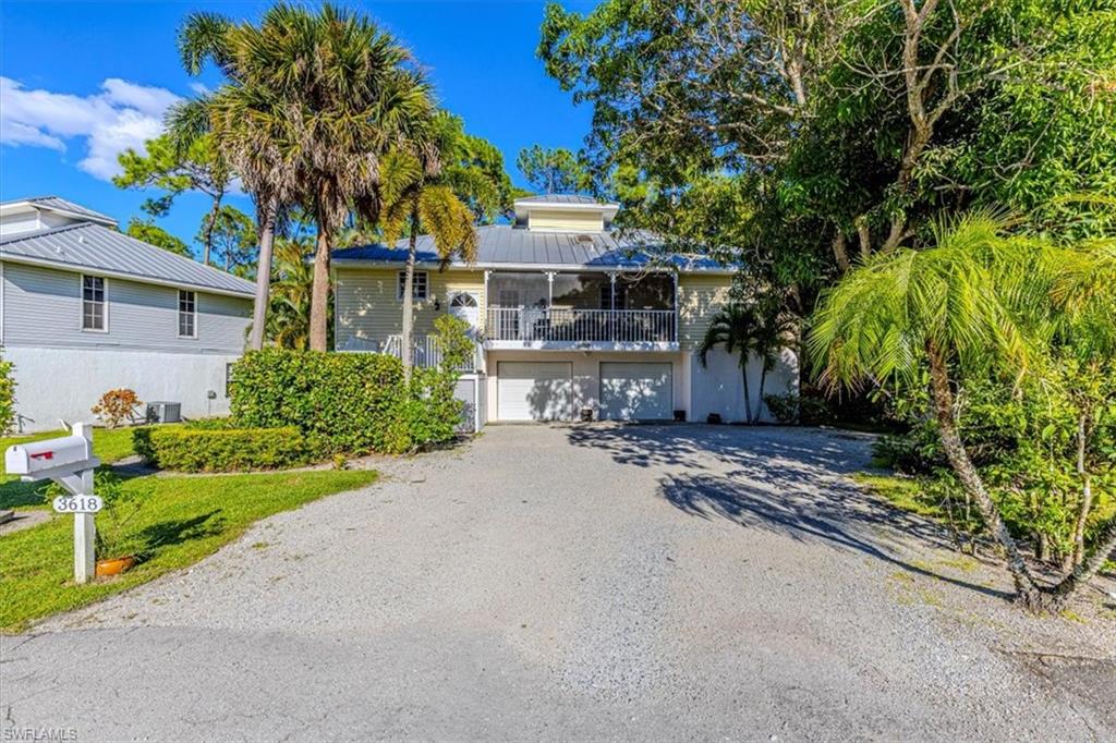 View of front of house with a balcony, driveway, and a garage