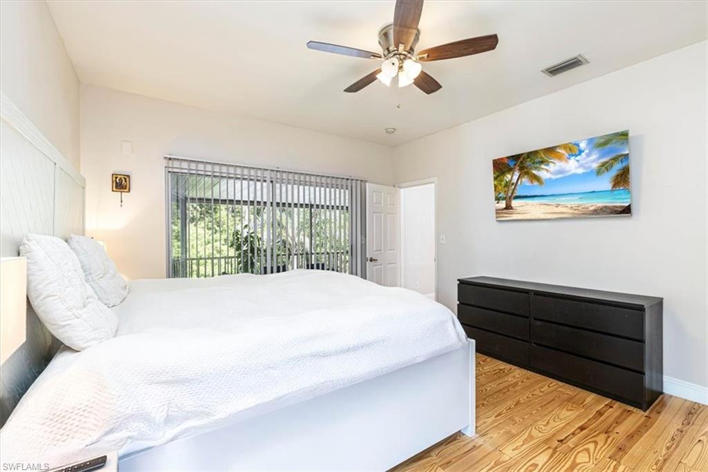 Bedroom with light wood-style floors, ceiling fan, and access to outside