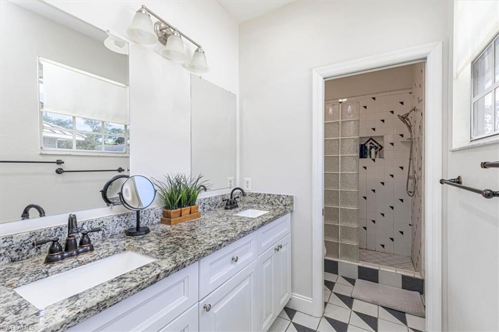 Full bathroom featuring a shower stall and double vanity