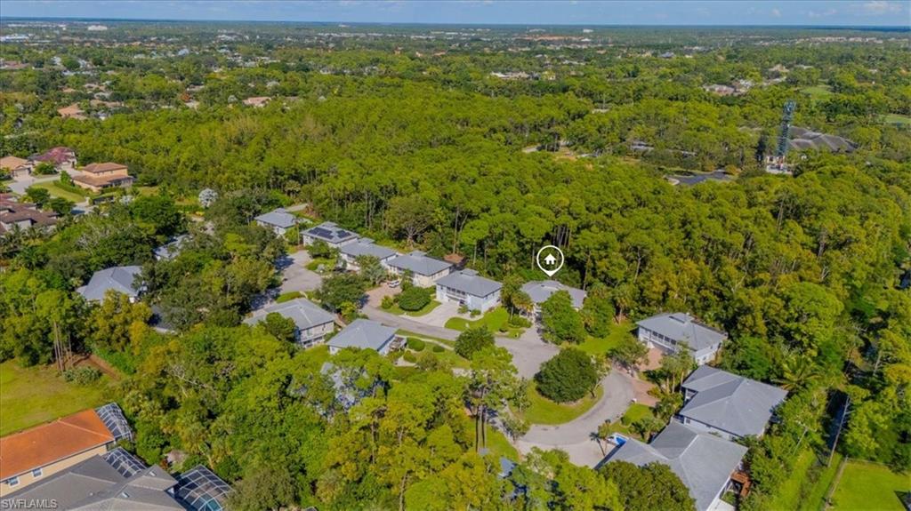 Aerial view of property and surrounding area with nearby suburban area and a forest