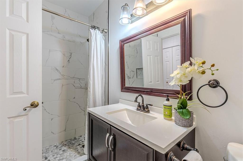 Full bathroom with a marble finish shower and vanity