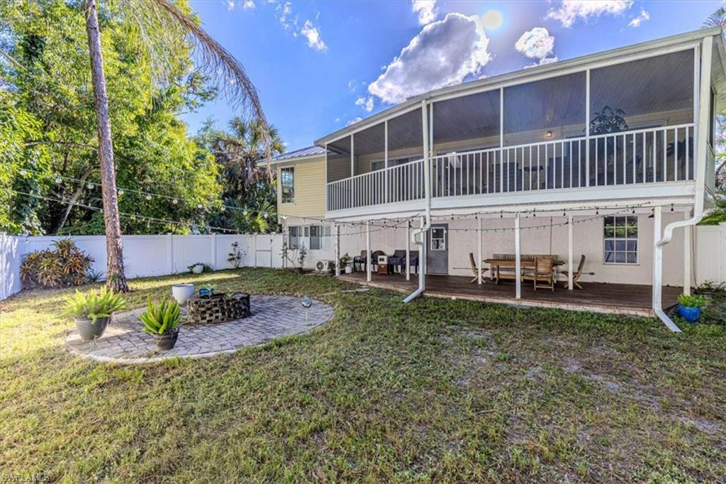 Fenced backyard featuring a patio, a sunroom, and a wooden deck