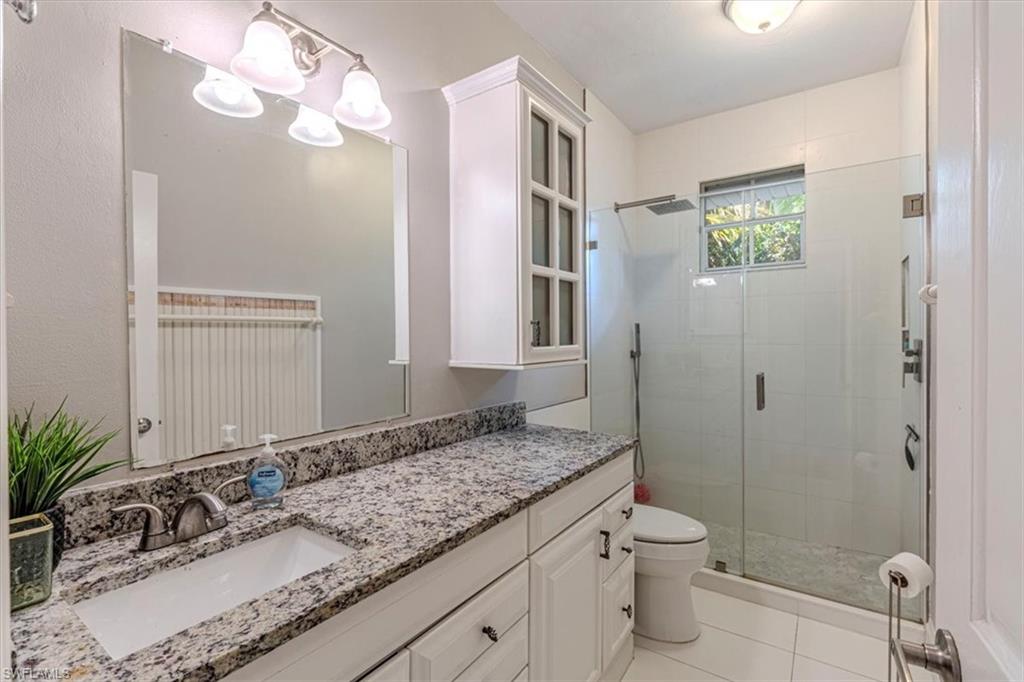 Bathroom featuring vanity, a stall shower, and light tile patterned floors