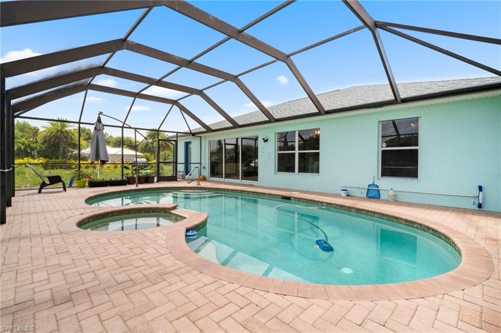 View of pool featuring a patio, a pool with connected hot tub, and a lanai