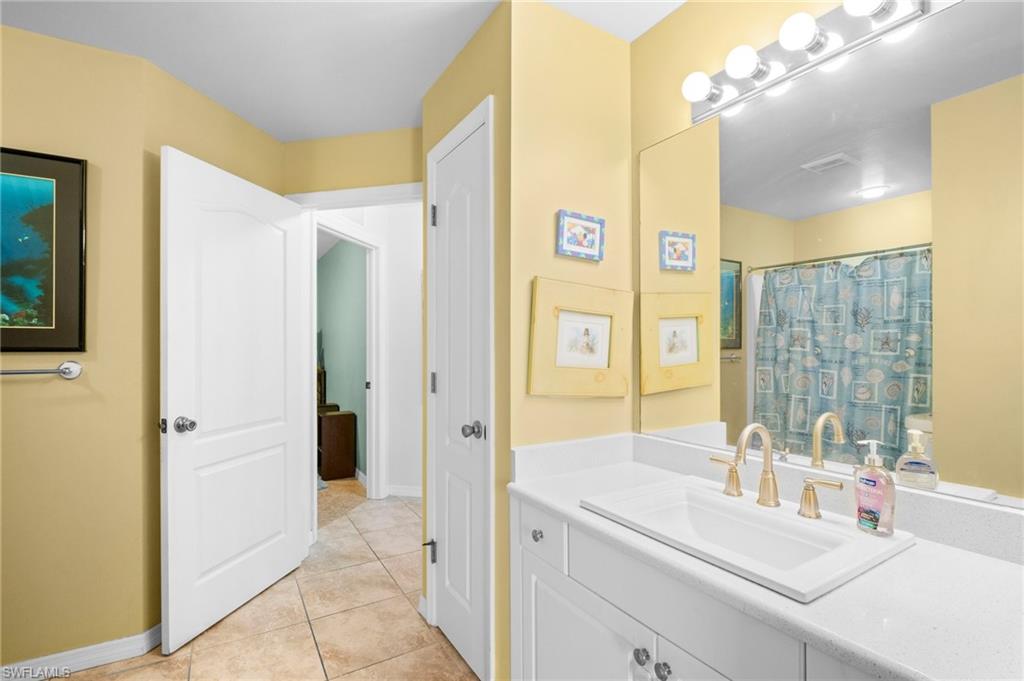 Full bathroom featuring vanity, baseboards, and tile patterned flooring