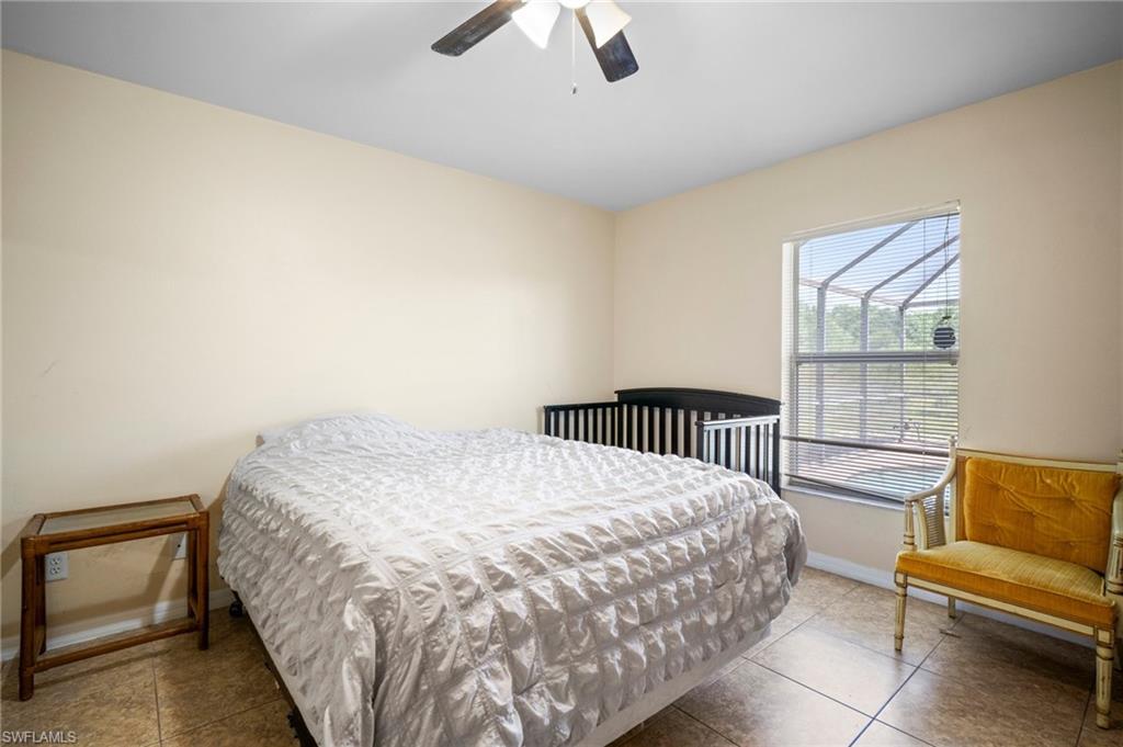 Bedroom featuring baseboards, tile patterned flooring, and a ceiling fan