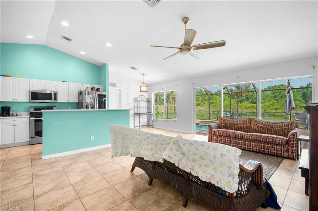 Living area featuring a ceiling fan, light tile patterned floors, recessed lighting, and high vaulted ceiling
