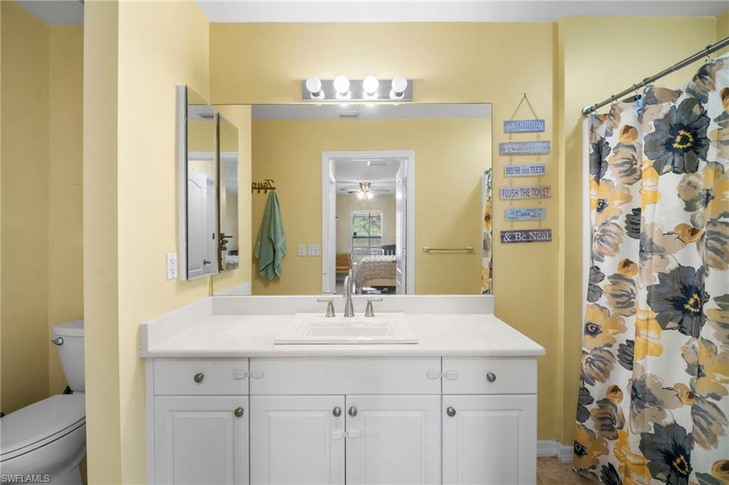 Ensuite bathroom with vanity, toilet, and a shower with curtain