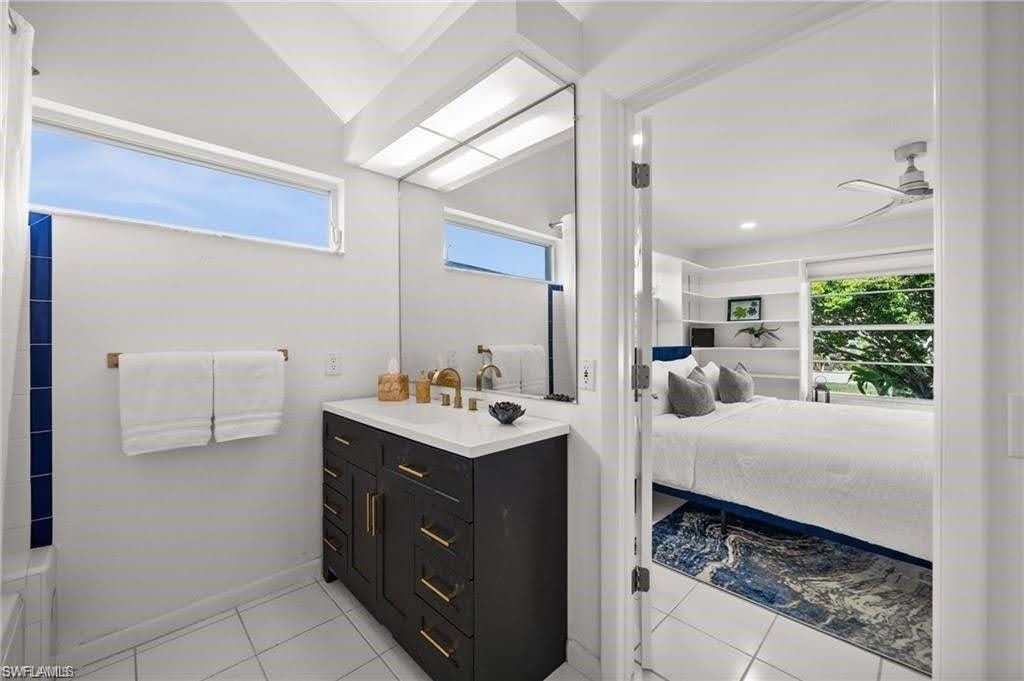 Bathroom featuring a dark vanity with gold hardware, white countertop, and a large mirror