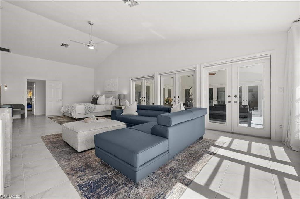Spacious primary featuring white tile flooring, vaulted ceilings, and a ceiling fan