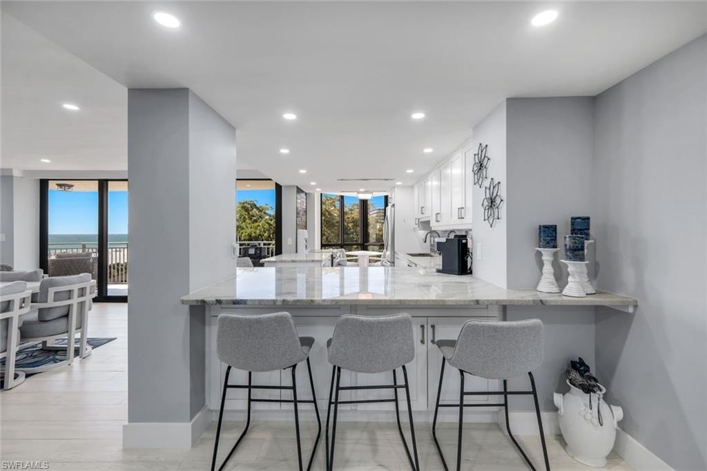 The property features a kitchen with white cabinetry and a light-colored countertop, complemented by recessed lighting