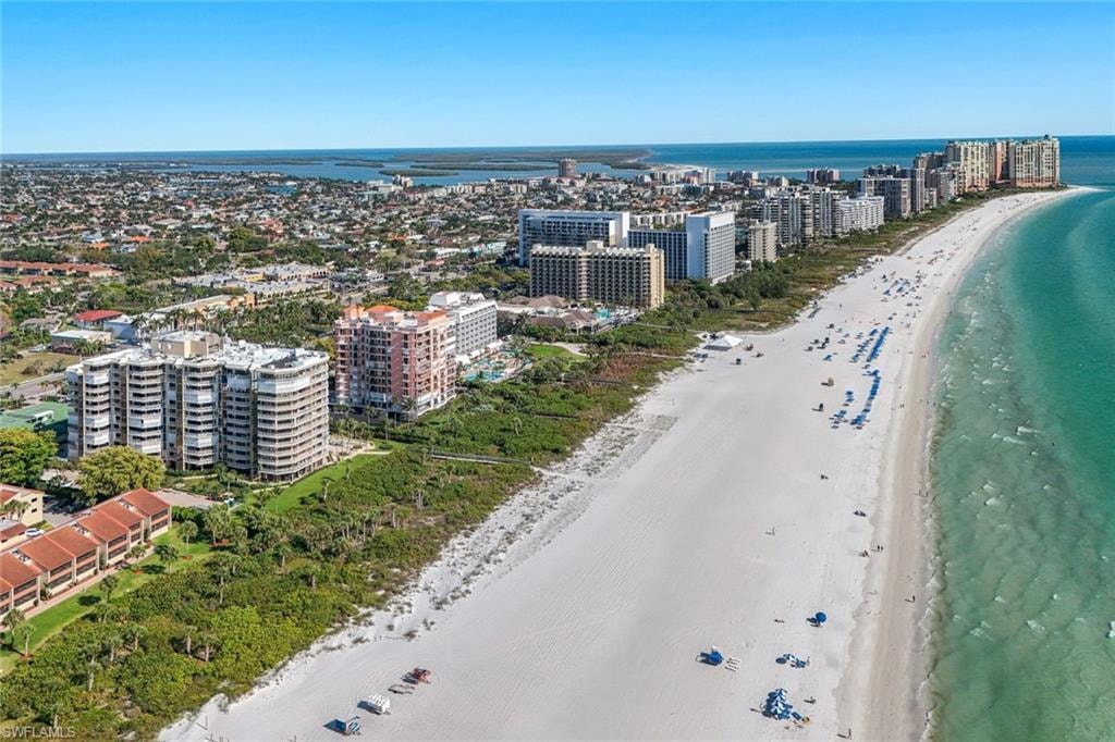 This aerial view highlights the expansive white sandy beach and the clear turquoise water