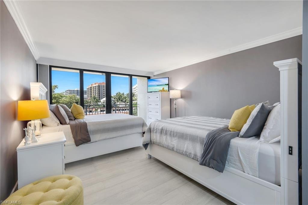 This room features light-colored flooring, full-height windows, and crown molding