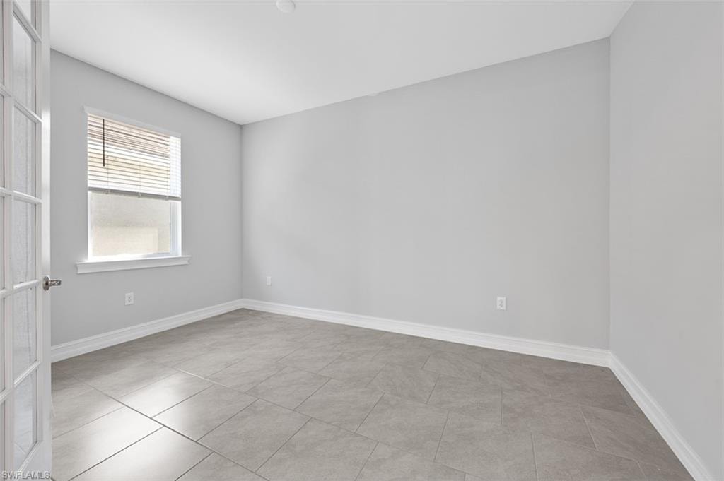 Unfurnished room with baseboards and light tile patterned floors