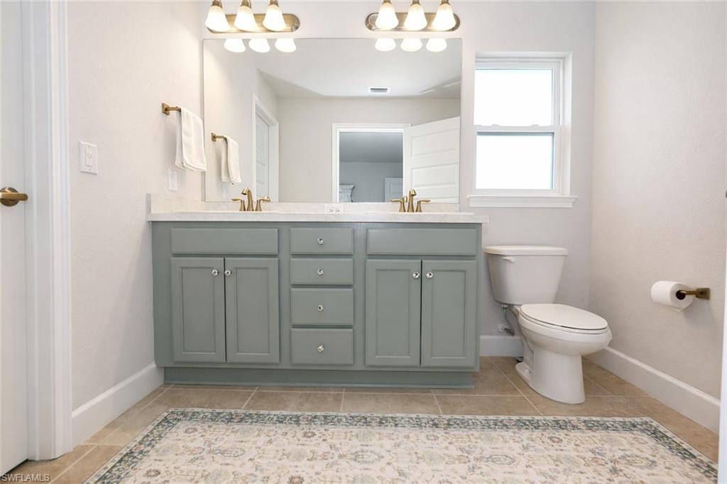 The bathroom features a double vanity with grey cabinetry and a light-colored countertop