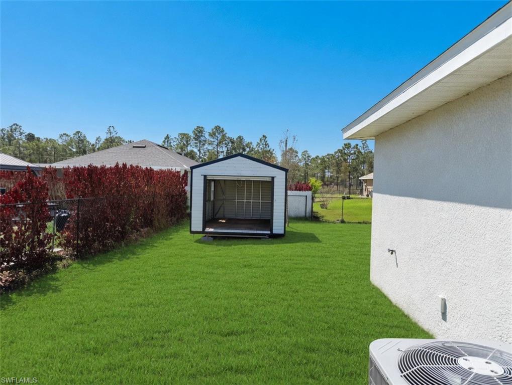 The property features a spacious backyard with a well-maintained lawn and a storage shed