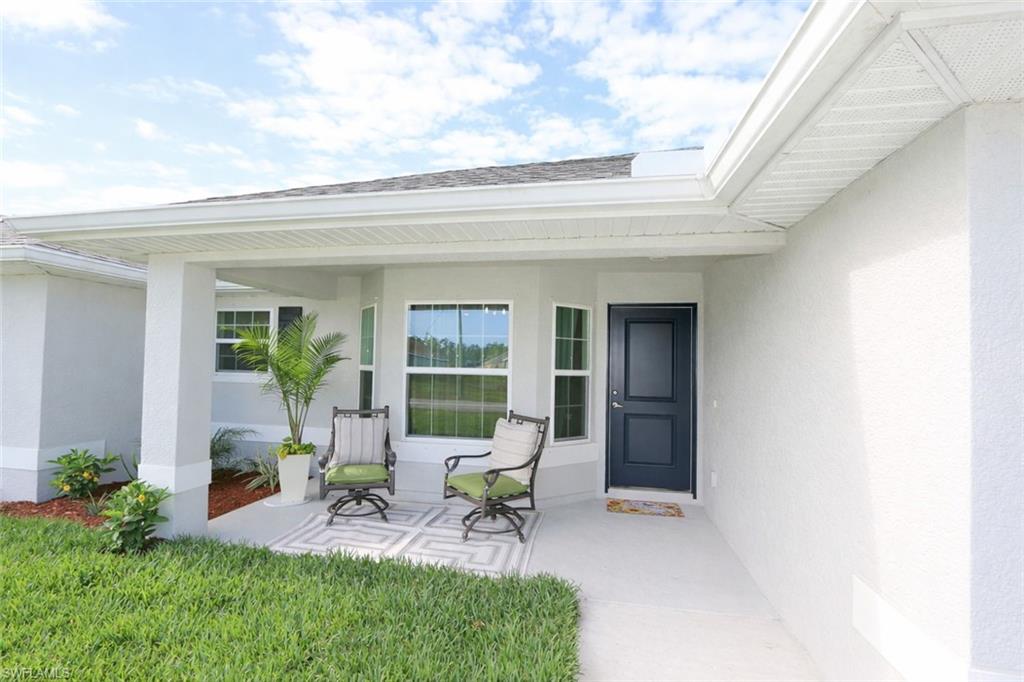 The property features a welcoming front entrance with a covered porch and a dark-paneled door