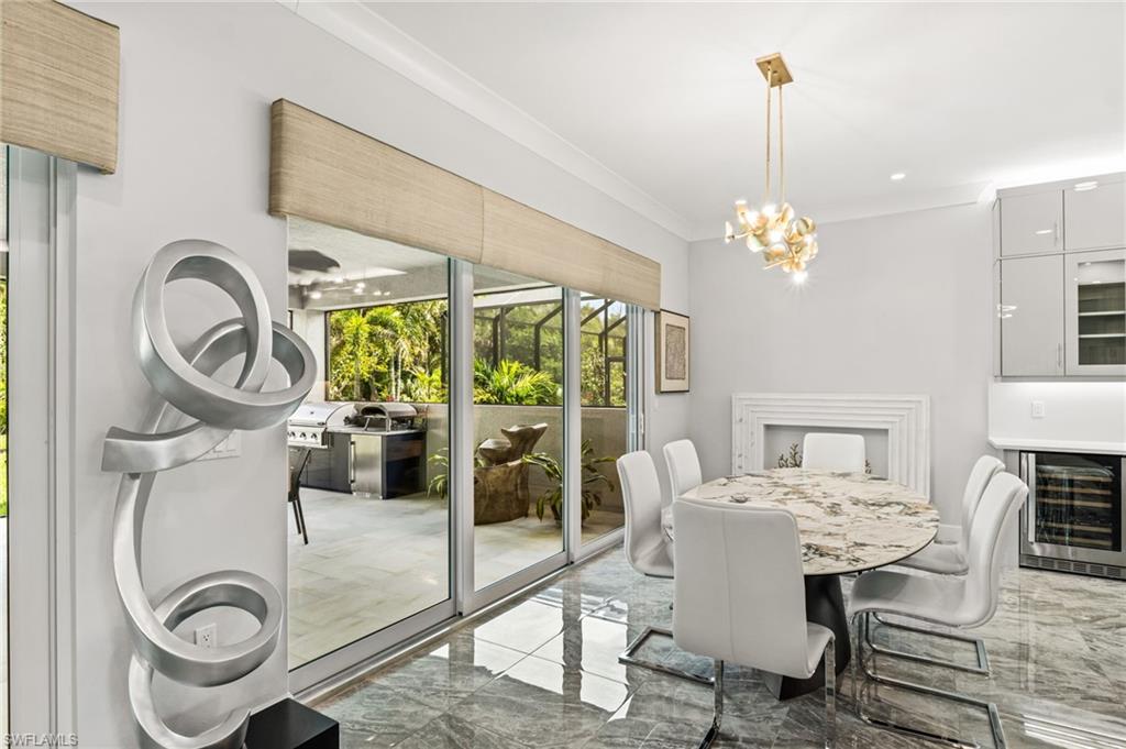 Stunning dining room with fireplace facade and 2 sets of sliders to the lanai