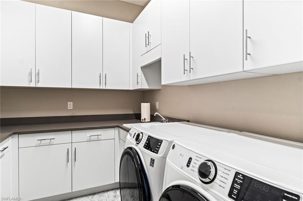 Abundant cabinetry, front loading washer and dryer, laundry sink
