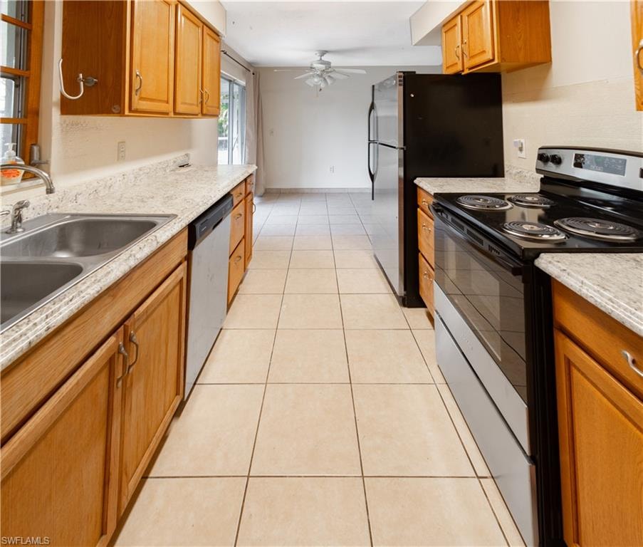 The kitchen features wood cabinetry, granite-style countertops, and a double basin stainless steel sink
