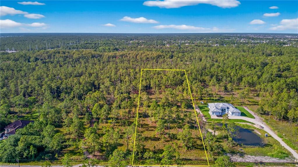 Aerial overview of property's location featuring property boundaries highlighted and a forest