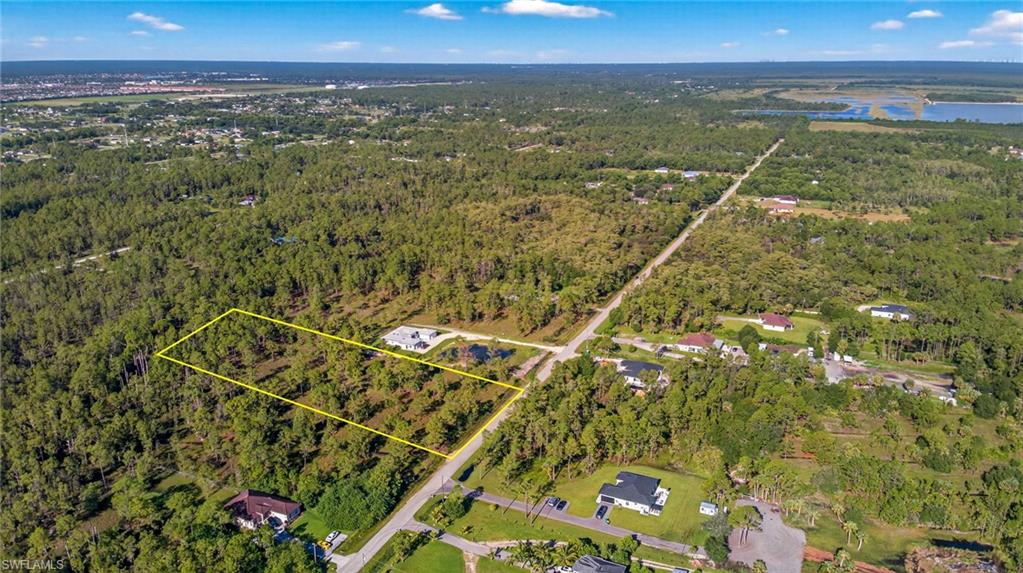 Aerial view of property and surrounding area featuring a nearby body of water and property boundaries highlighted