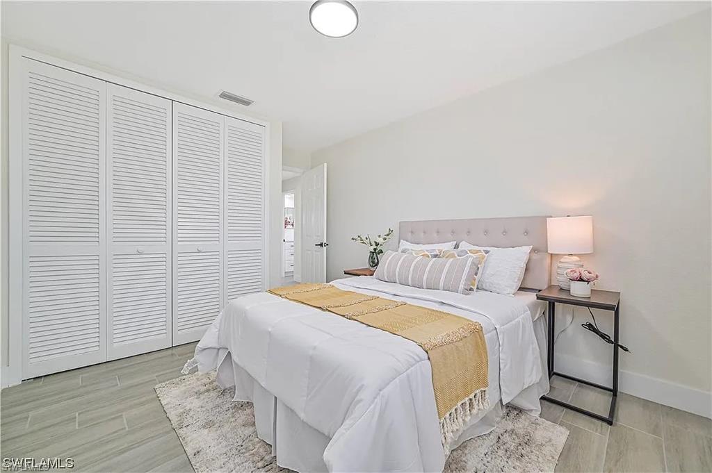This room features large louvered closet doors, light-colored walls, and tile flooring