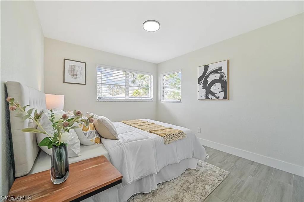 Bedroom featuring light-colored walls, recessed lighting, and windows with blinds