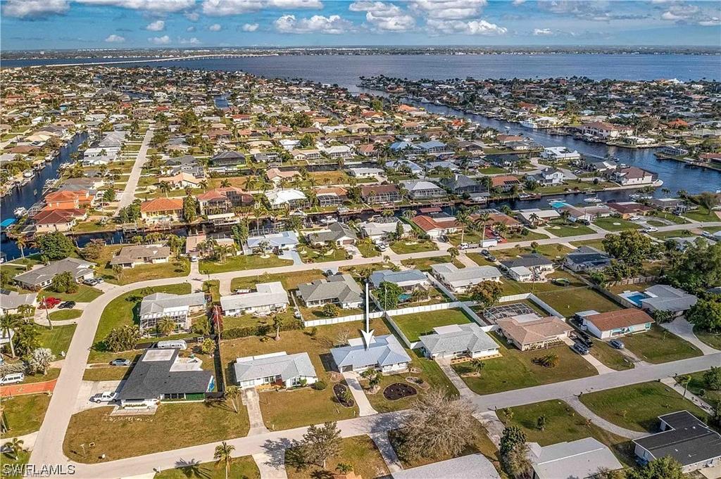 This aerial view showcases the property within a neighborhood featuring waterways and residential structures