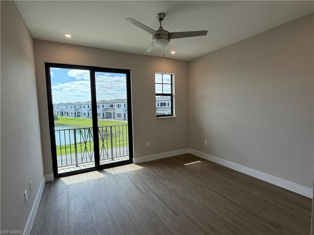 This room features wood-look flooring, a ceiling fan with integrated lighting, and recessed lighting