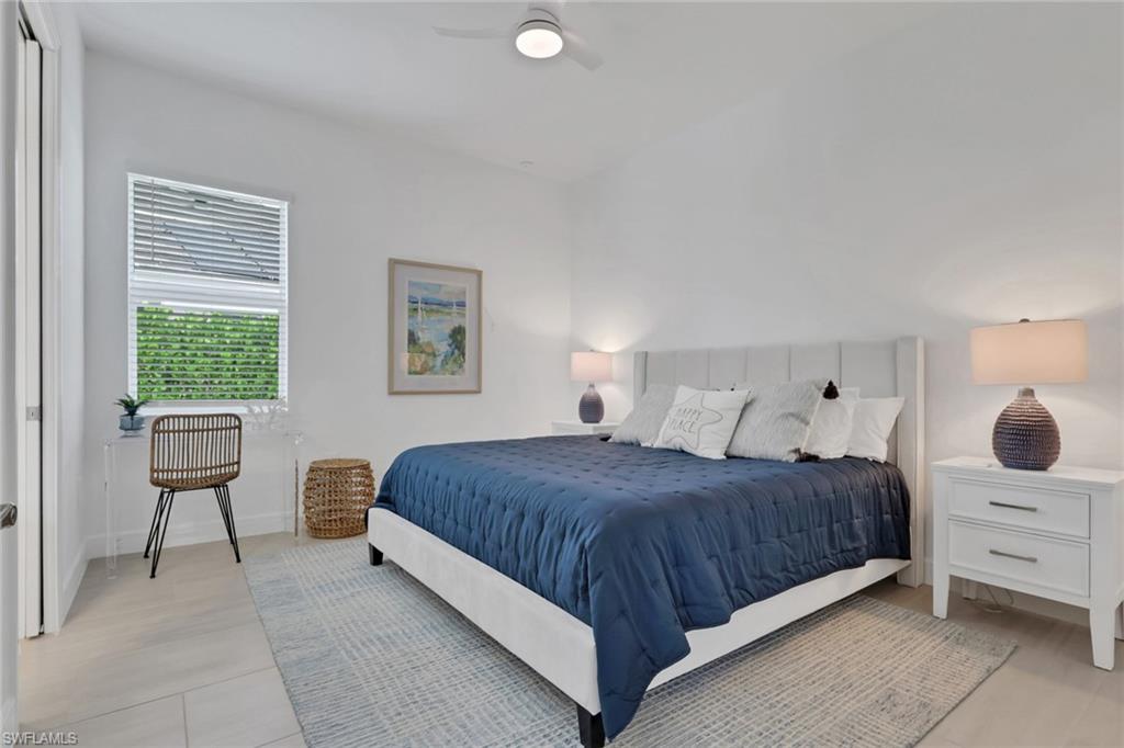 Spacious room featuring light-toned flooring, a window with blinds, and white walls