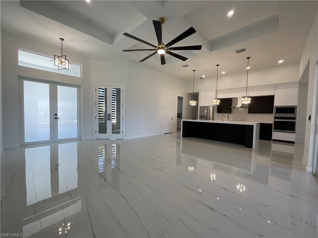 The property features an open-concept living space with polished tile flooring, a contemporary kitchen with a large island, and recessed lighting