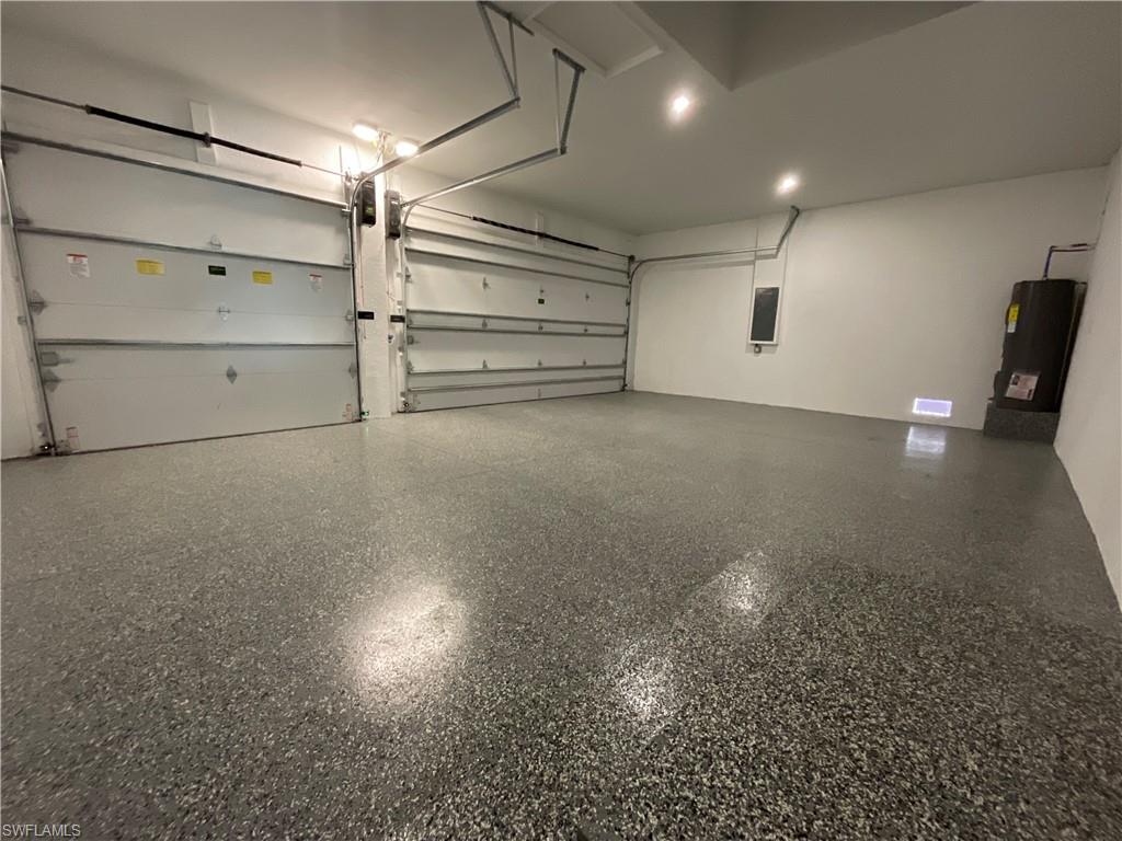 This expansive garage features two overhead doors, a textured floor, and recessed lighting