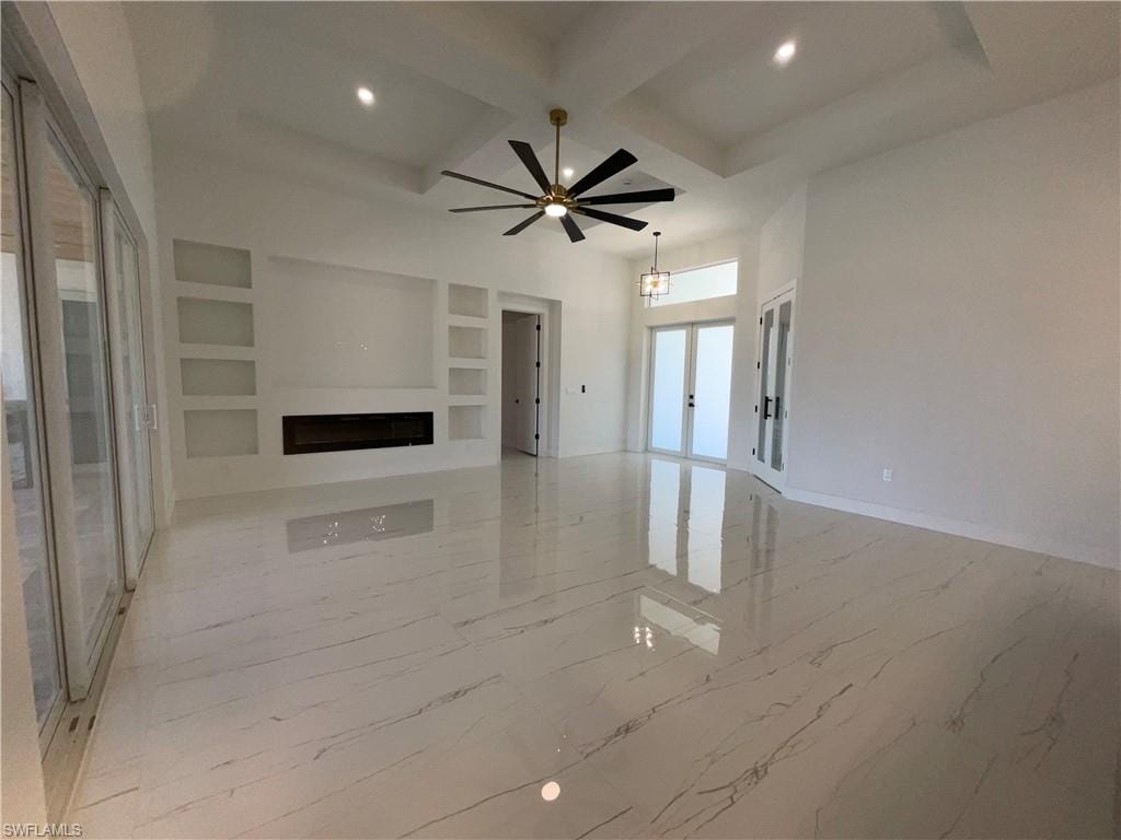 This expansive living area features large format tile flooring, a modern linear fireplace, and built-in shelving